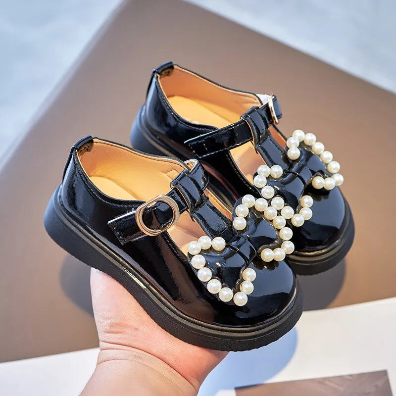 A imagem destaca o modelo na cor preto do Sapato Infantil Feminino em Couro Com Pérolas