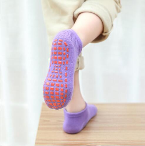 A imagem mostra uma criança usando a meia antiderrapante.