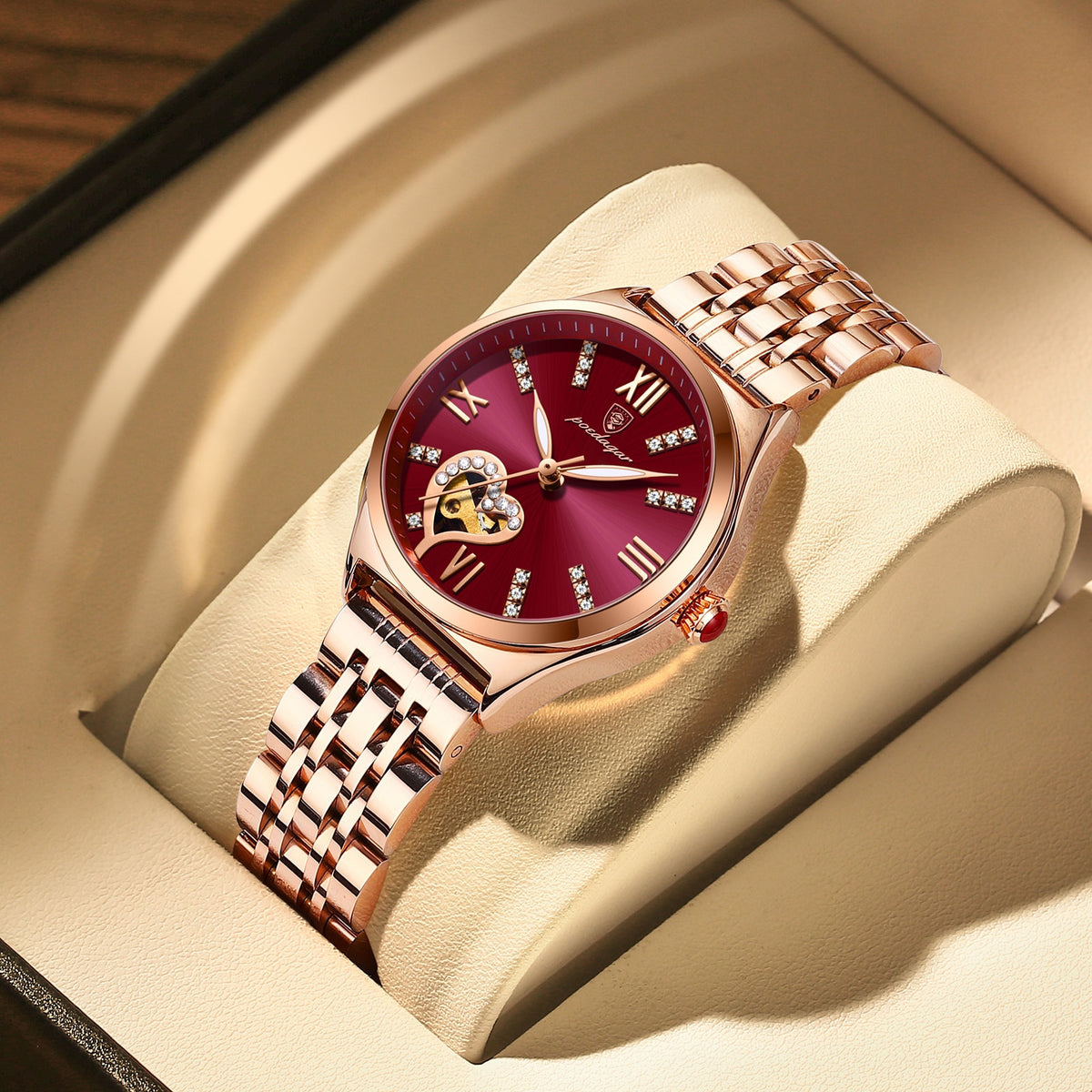 A imagem mostra o relógio da cor ouro rose e visor vermelho.