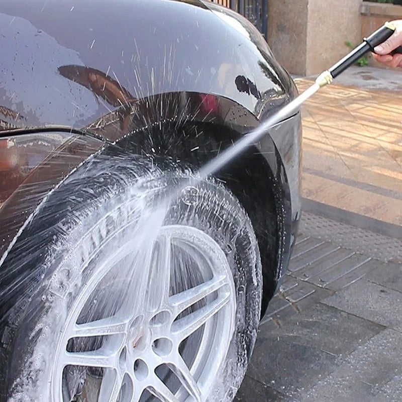 A imagem mostra uma pessoa utilizando a pistola de água para lavar as rodas do automóvel.
