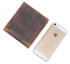 Carteira de couro marrom ao lado de um iPhone dourado