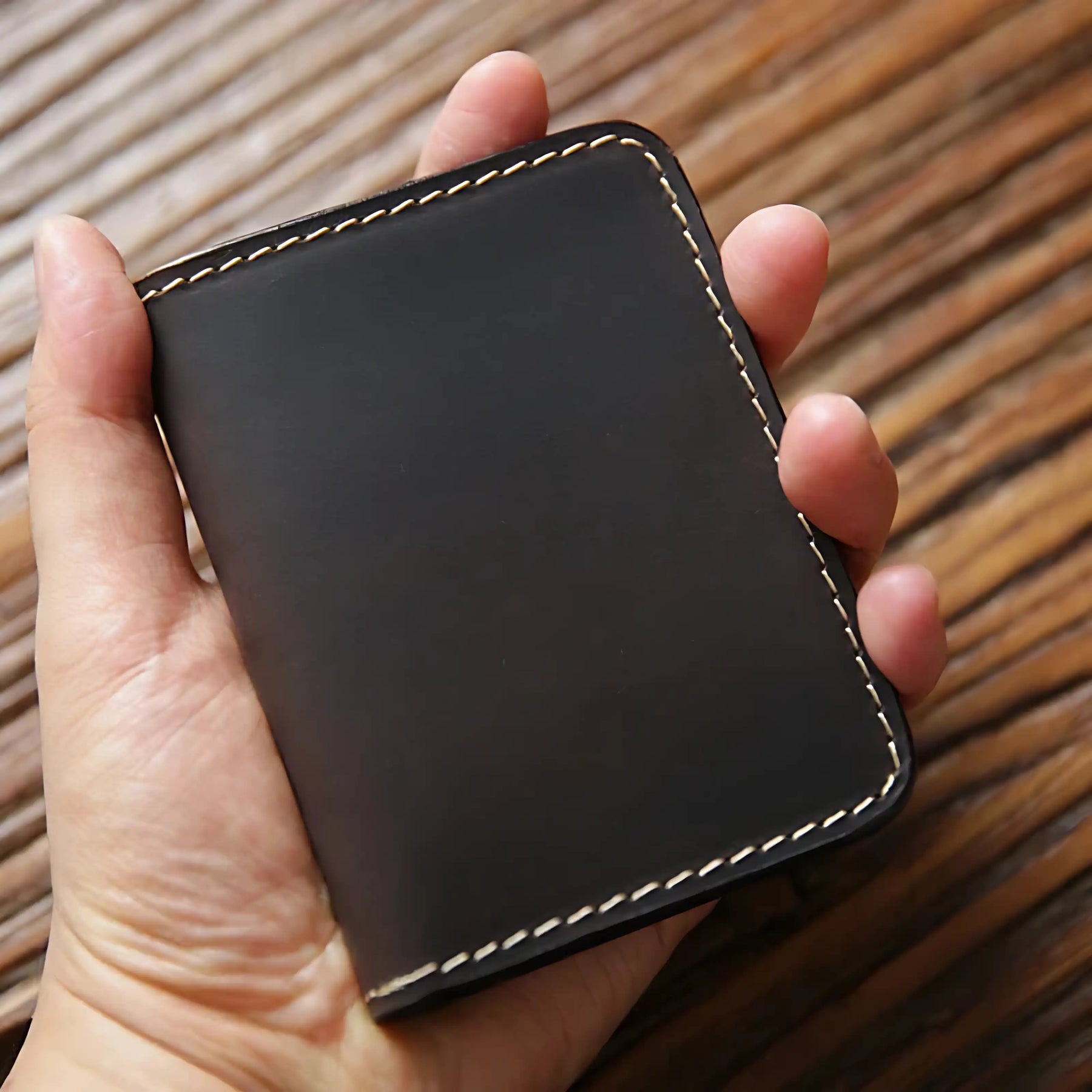 Carteira de couro preto, design minimalista, ideal para organização de cartões.