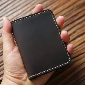 Carteira de couro preto, design minimalista, ideal para organização de cartões.