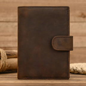 Capa de bolsa de couro marrom com fechamento e design minimalista.
