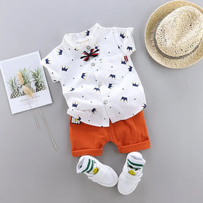 A imagem mostra o modelo do Conjunto Infantil Masculino Camisa e Short Coroa na cor branca