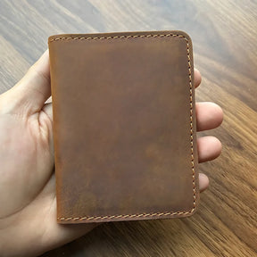 Carteira de couro marrom em uma mão, design simples e elegante para homens.
