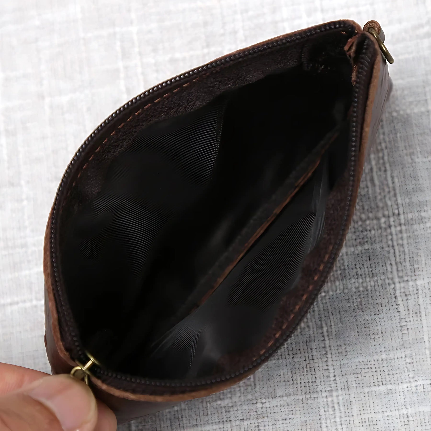 Porta-moeda de couro marrom com interior preto, ideal para organização de moedas.