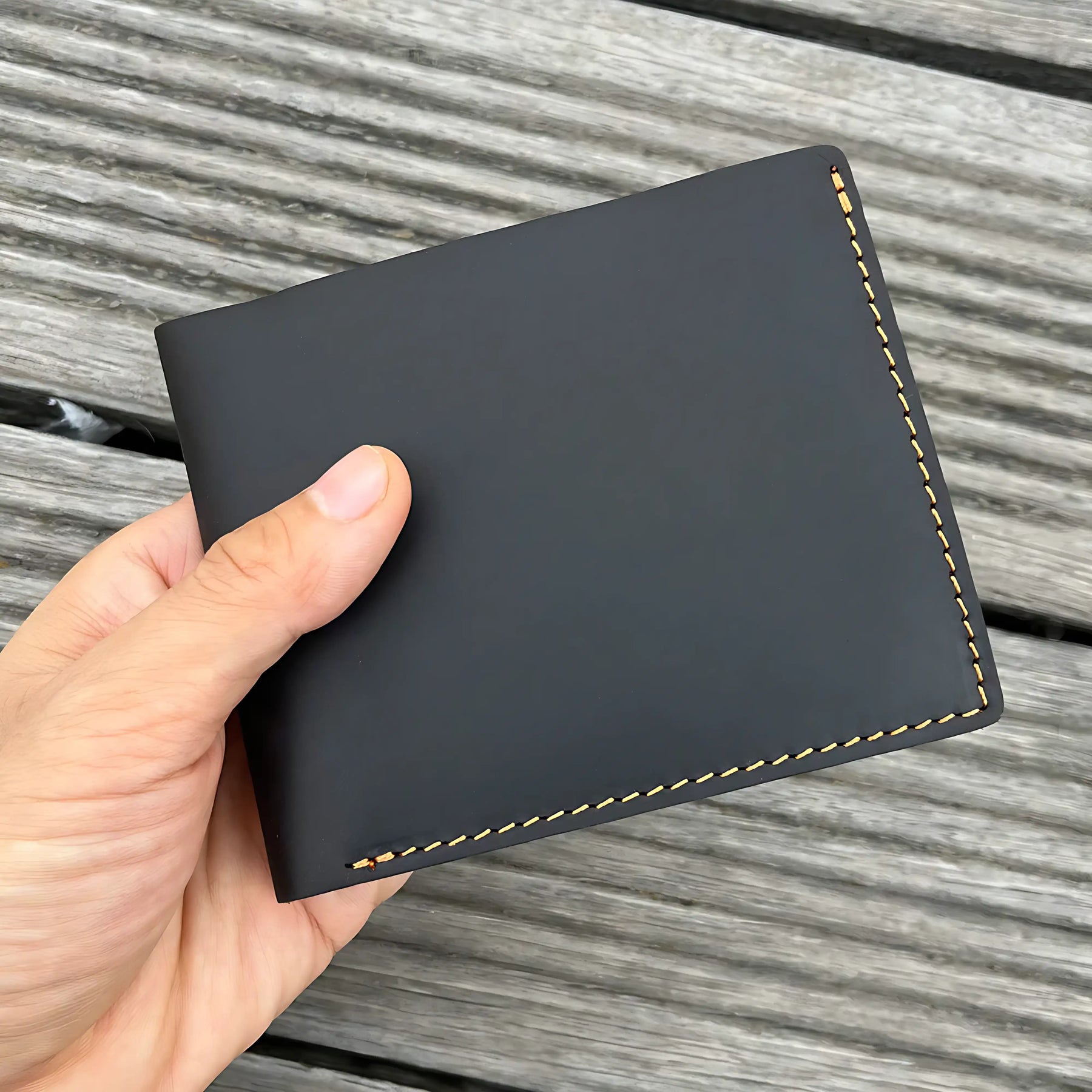 Carteira masculina de couro preto com costura marrom, design elegante e minimalista.