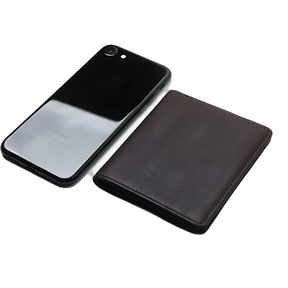 Carteira de couro marrom próxima a celular, design elegante e compacto.