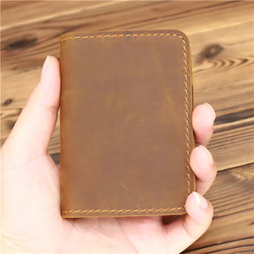 Carteira de couro marrom, estilo minimalista, segurada na mão.