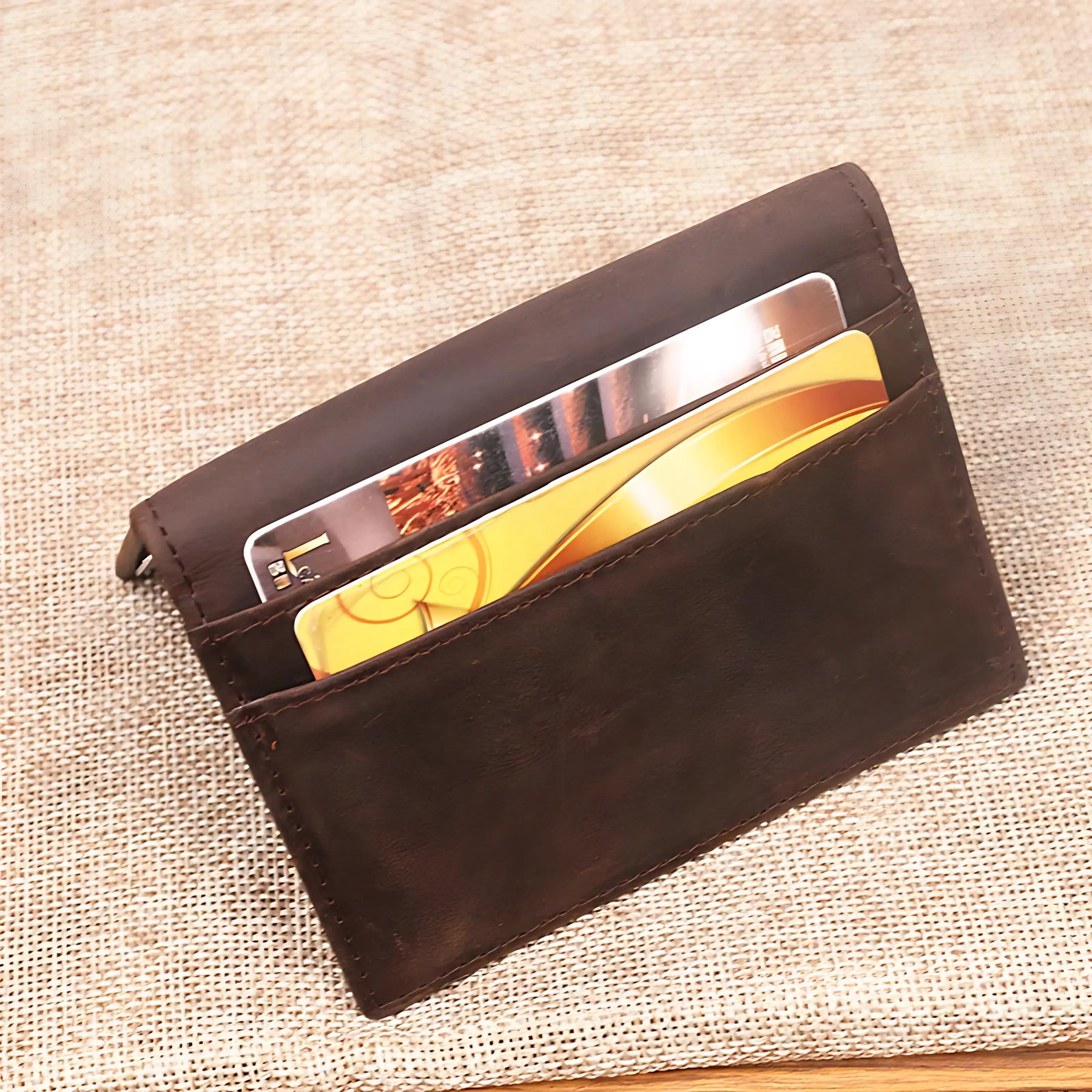 Porta-cartões de couro marrom com cartões visíveis, ideal para organização.