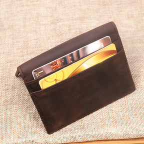 Porta-cartões de couro marrom com cartões visíveis, ideal para organização.