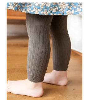 calça legging infantil feminina na cor cinza escuro sendo usada por uma criança.