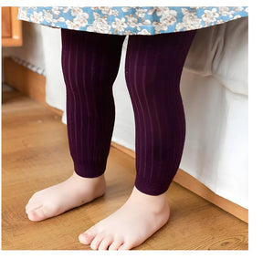 calça legging infantil feminina na cor roxo sendo usada por uma criança.