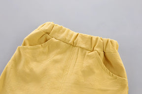 conjunto infantil masculino camisa e short modelo na cor amarelo destacando o short.