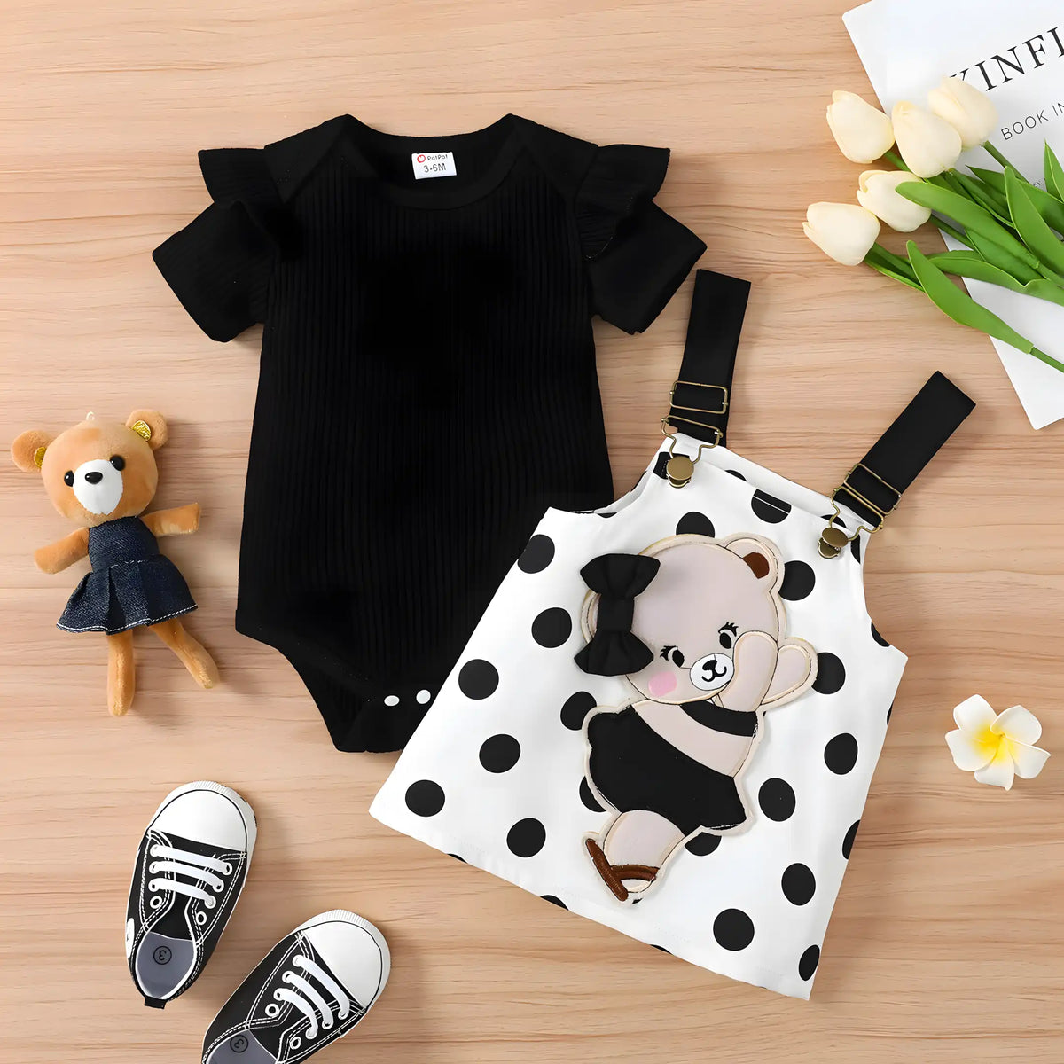 conjunto infantil para menina body e vestido bordado em exibição.