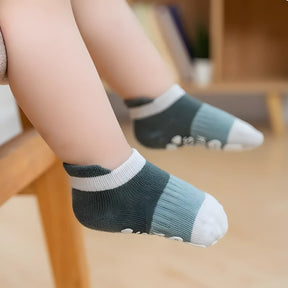 Criança usando uma meia infantil antiderrapante do kit 02.