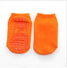 meia infantil antiderrapante na cor laranja em um fundo branco