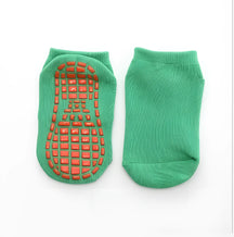 meia infantil antiderrapante na cor verde escuro em um fundo branco.