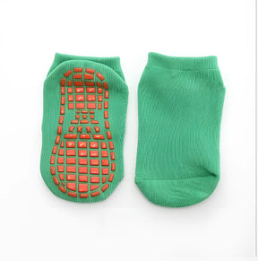 meia infantil antiderrapante na cor verde escuro em um fundo branco.