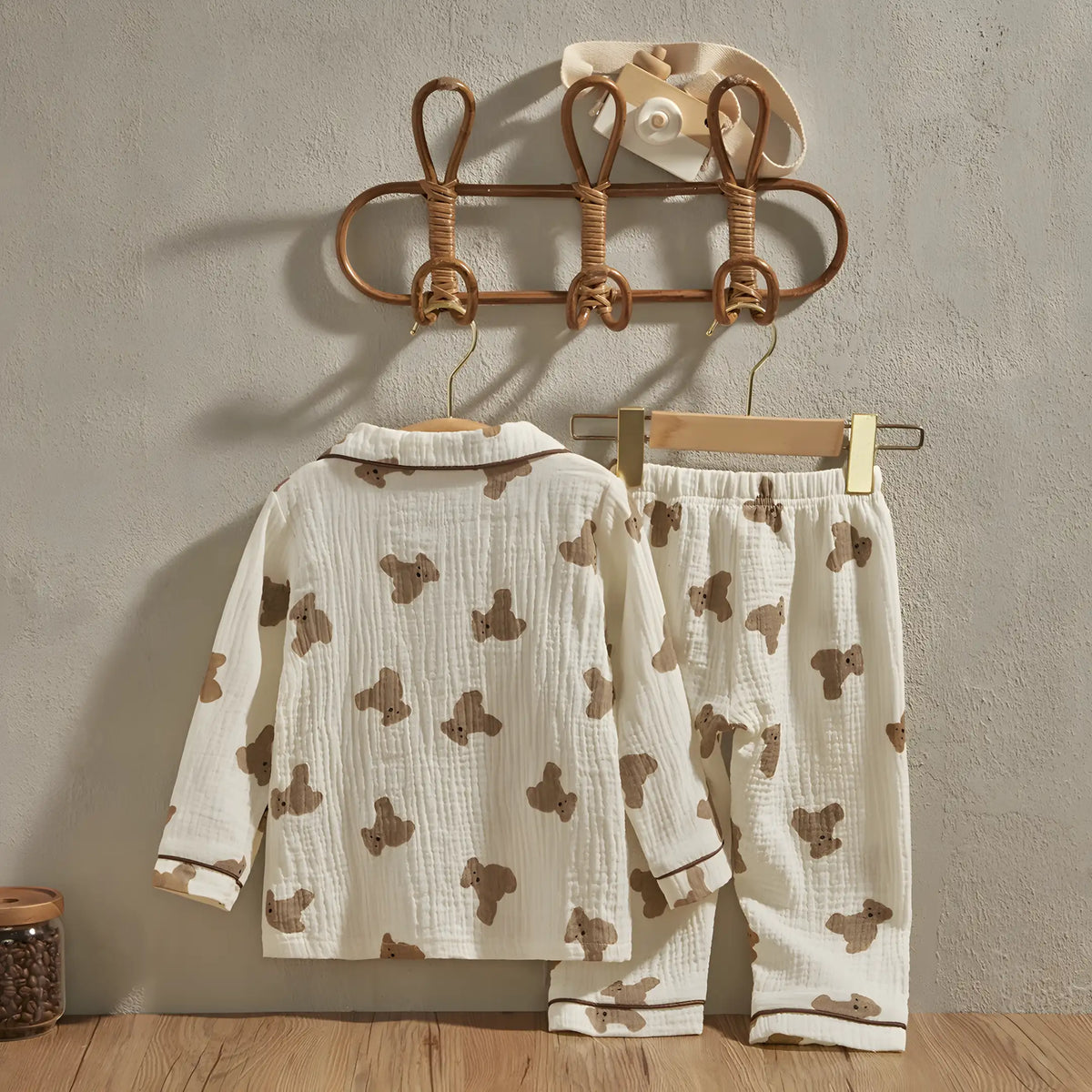 pijama infantil casual exibindo a parte traseira pendurado em cabide encostados na parede.