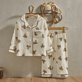 pijama infantil casual exibindo a parte frontal pendurado em cabide encostados na parede.
