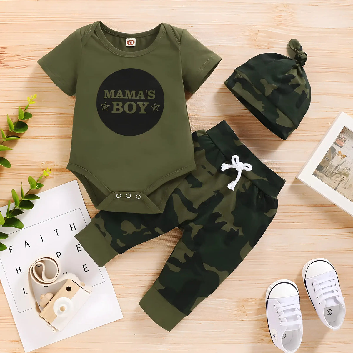 conjunto recém nascido com camisa, calça e touca exposto ao lado de um tênis.